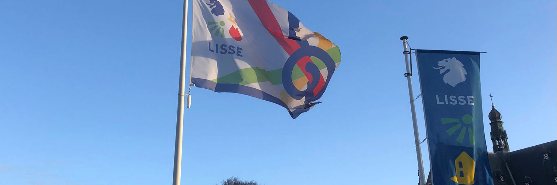 Vlag van de inclusieve samenleving naast de vlag van Lisse